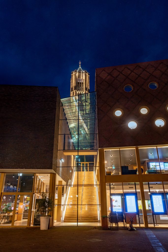 Focus filmtheater Arnhem vooraanzicht met trap met led leuningen gemonteerd aan glazen balustrade en de Eusebiuskerk op de achtergrond.