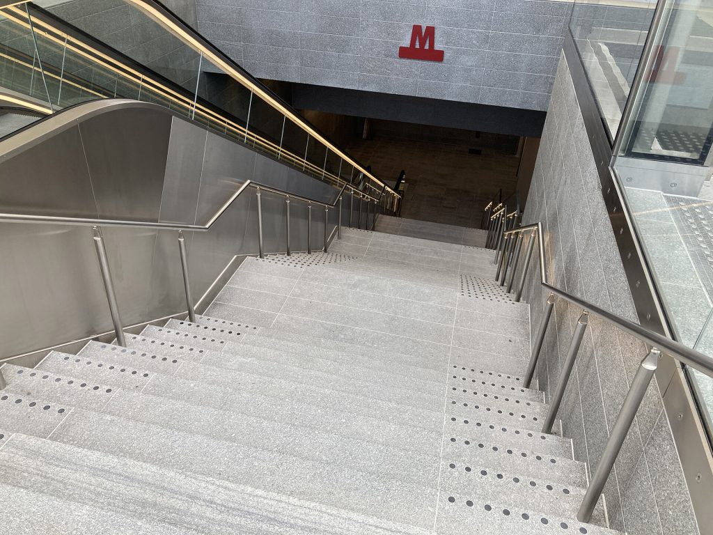 Metrostation Kopenhagen verlichte trapleuningen ingang met roltrap