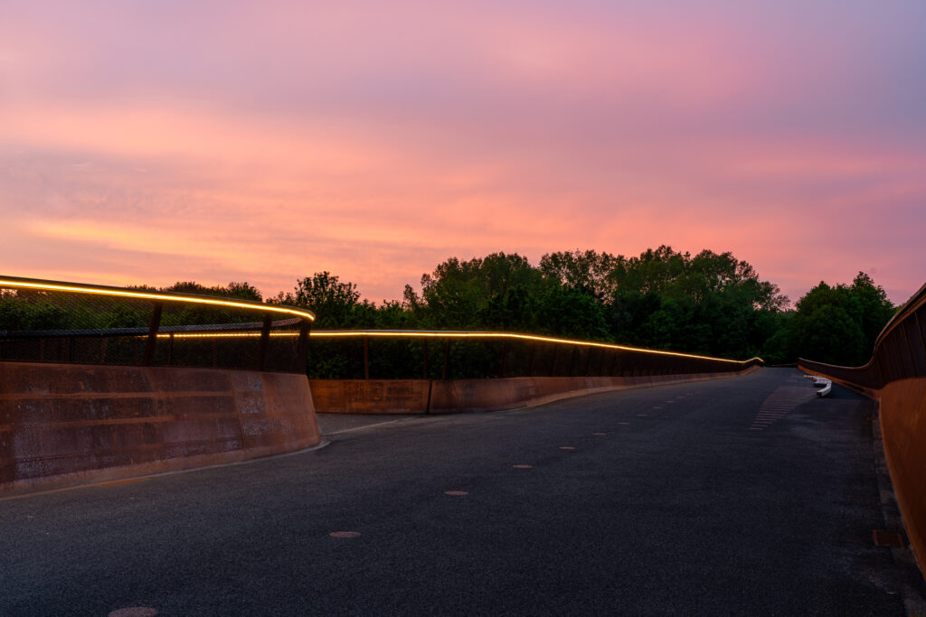 ILLUNOX LED leuning van de Cirkelbrug Almere. De LED verlichting is hier ingebouwd in de hardhouten leuning van de bovenrail van de brug. Bijzonder zijn de buigingen van de brug en de spiltrap, waarin de verlichting ook spiraalvormig doorloopt met de vorm van de brug mee.